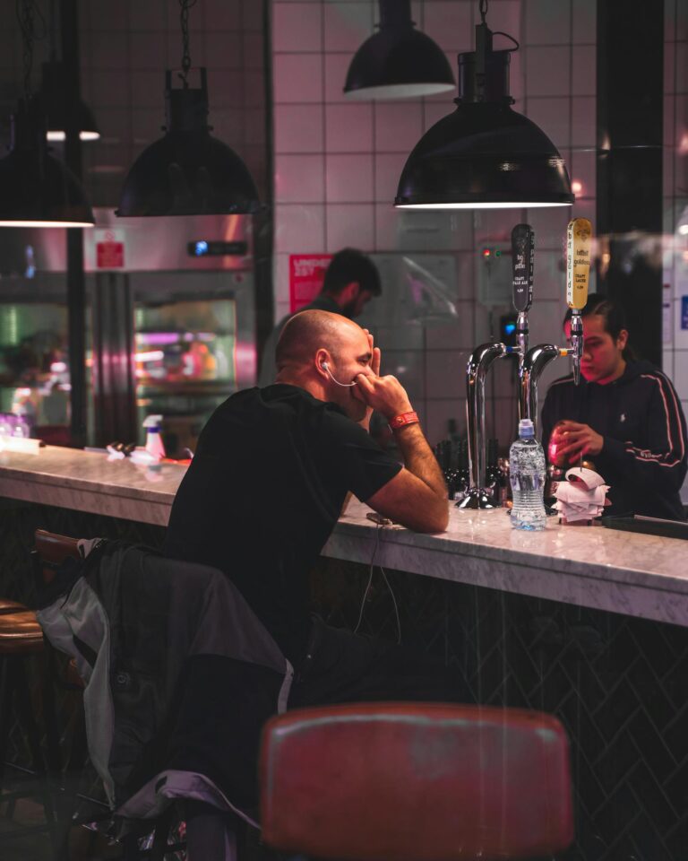 A modern bar setting with people enjoying drinks in a cozy ambiance.